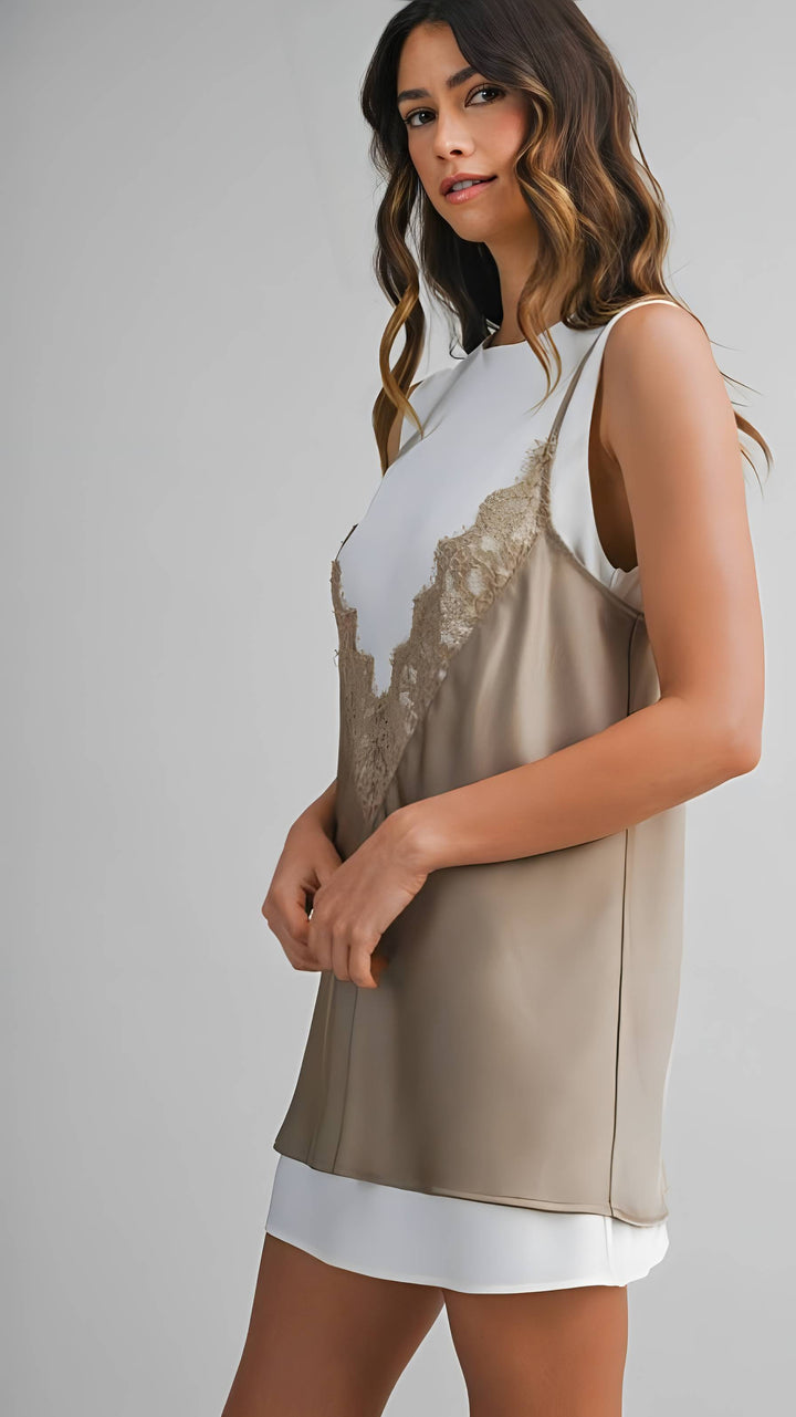 Woman wearing a sleeveless dress with a beige and white design on a gray background
