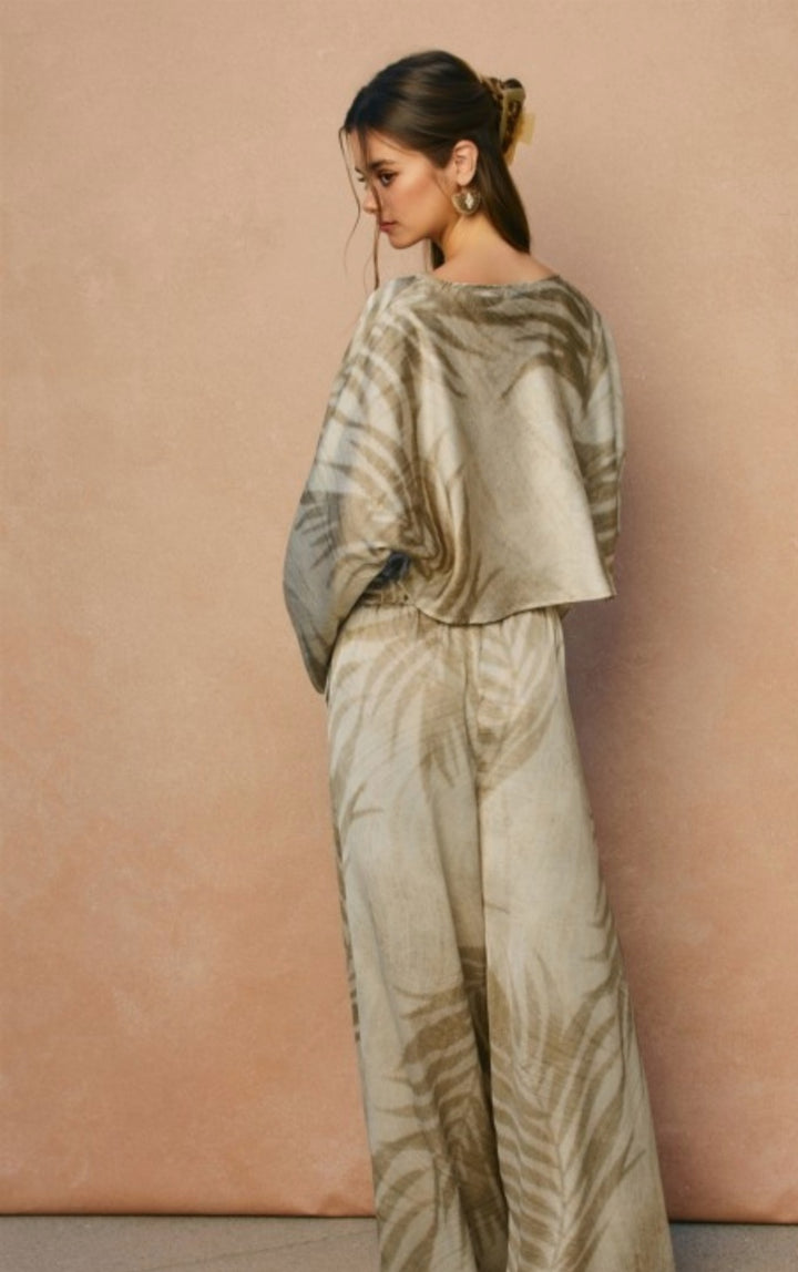 Woman wearing a patterned outfit against a beige background
