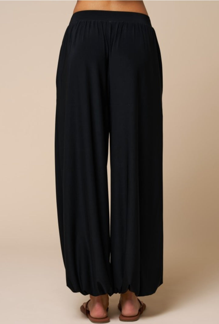 Black wide-leg pants on a beige background
