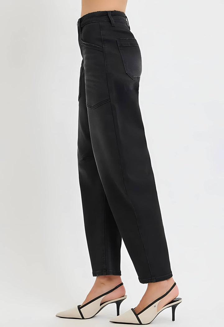 A side view of a model wearing black wide-leg cropped jeans and beige slingback heels against a plain white studio background.
