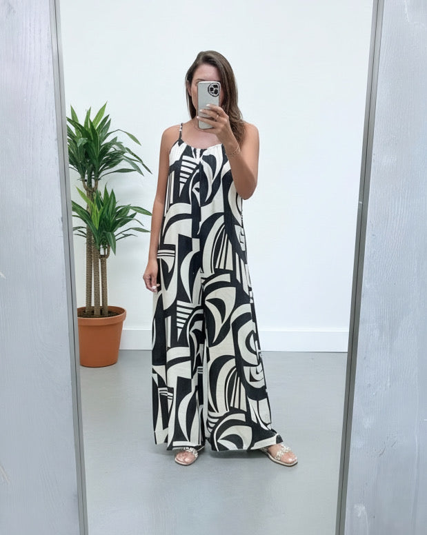 Woman taking a mirror selfie wearing a black and white patterned dress.
