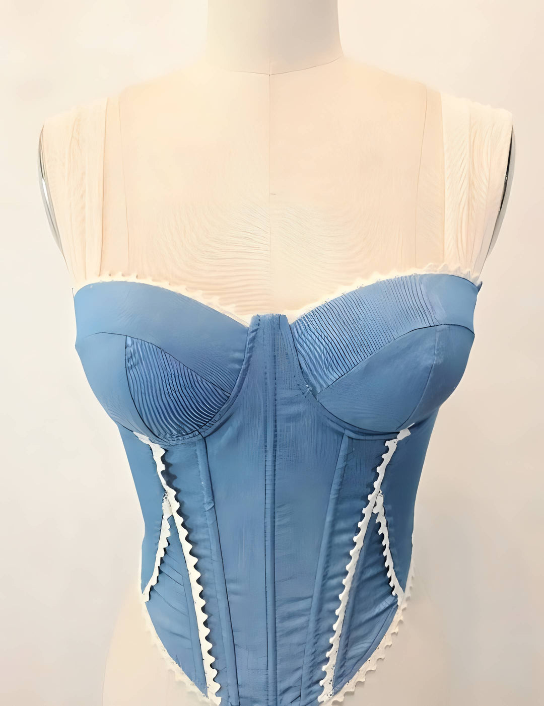 Blue corset on a mannequin against a plain background