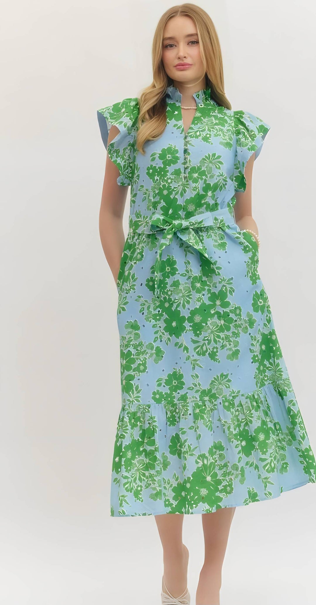 Woman wearing a green and blue floral dress on a white background