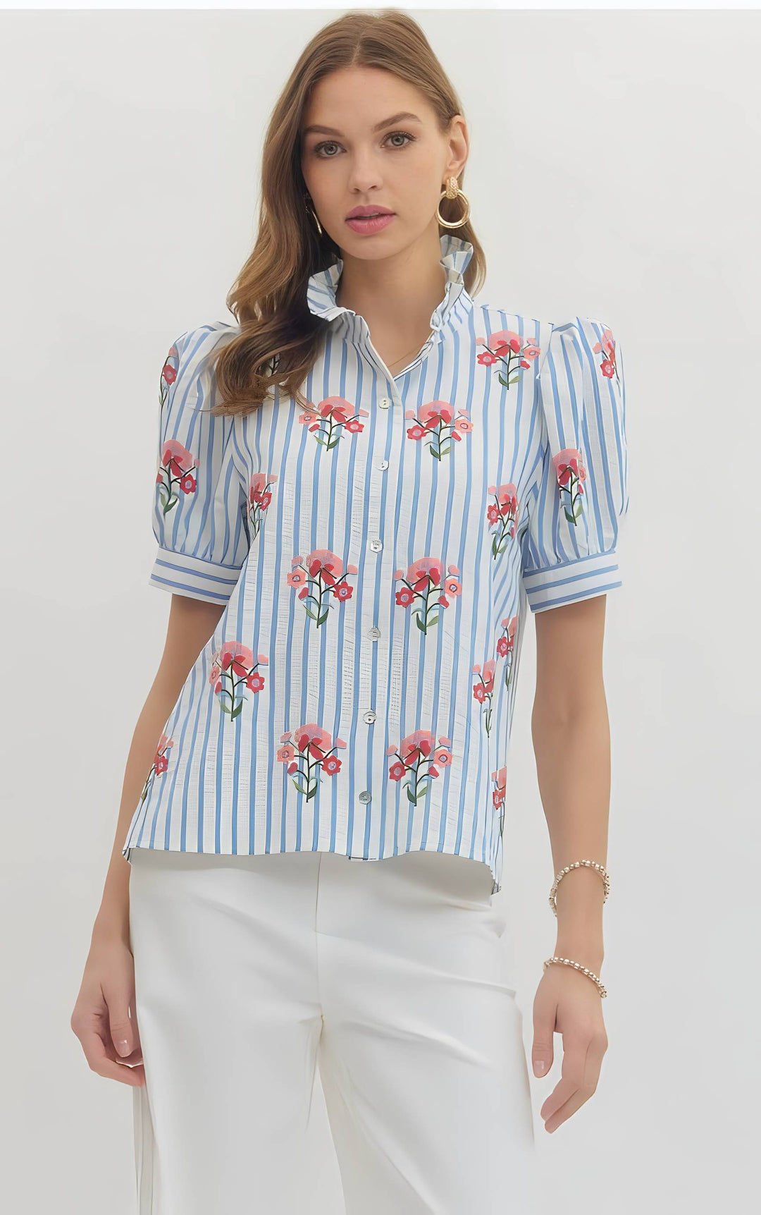 Woman wearing a blue striped shirt with floral patterns on a white background