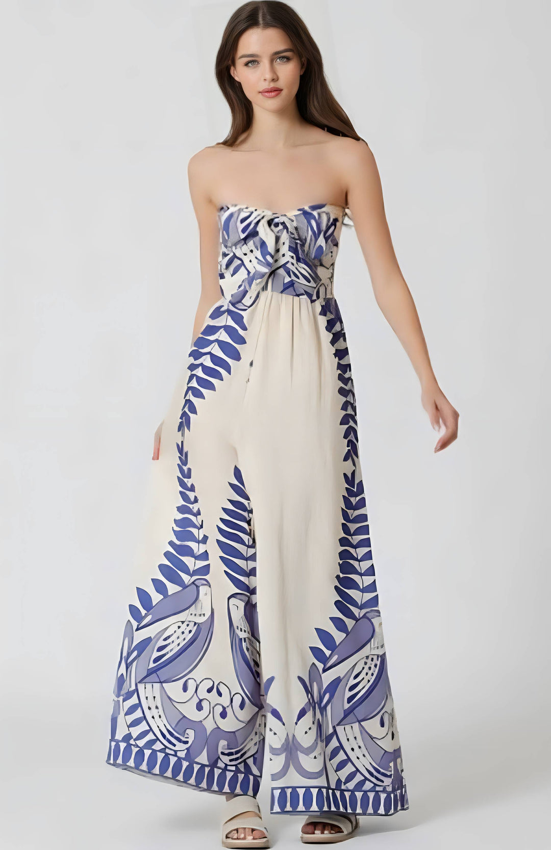 Woman wearing a strapless dress with blue and white floral pattern on a white background