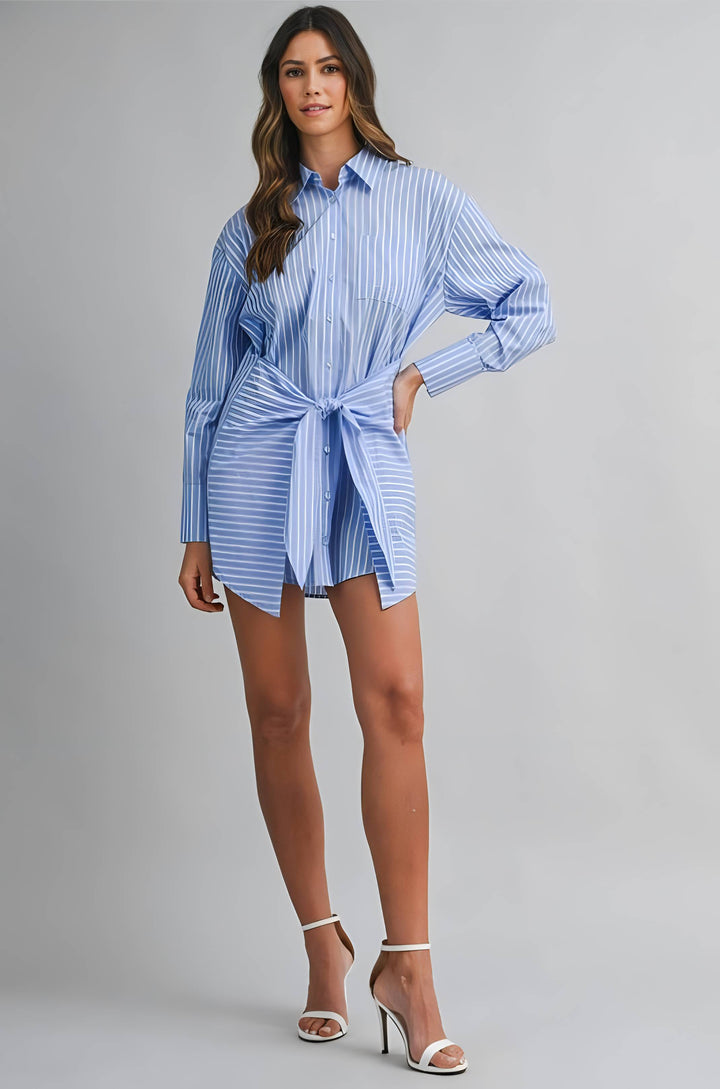 Woman wearing a blue and white striped shirt dress on a gray background