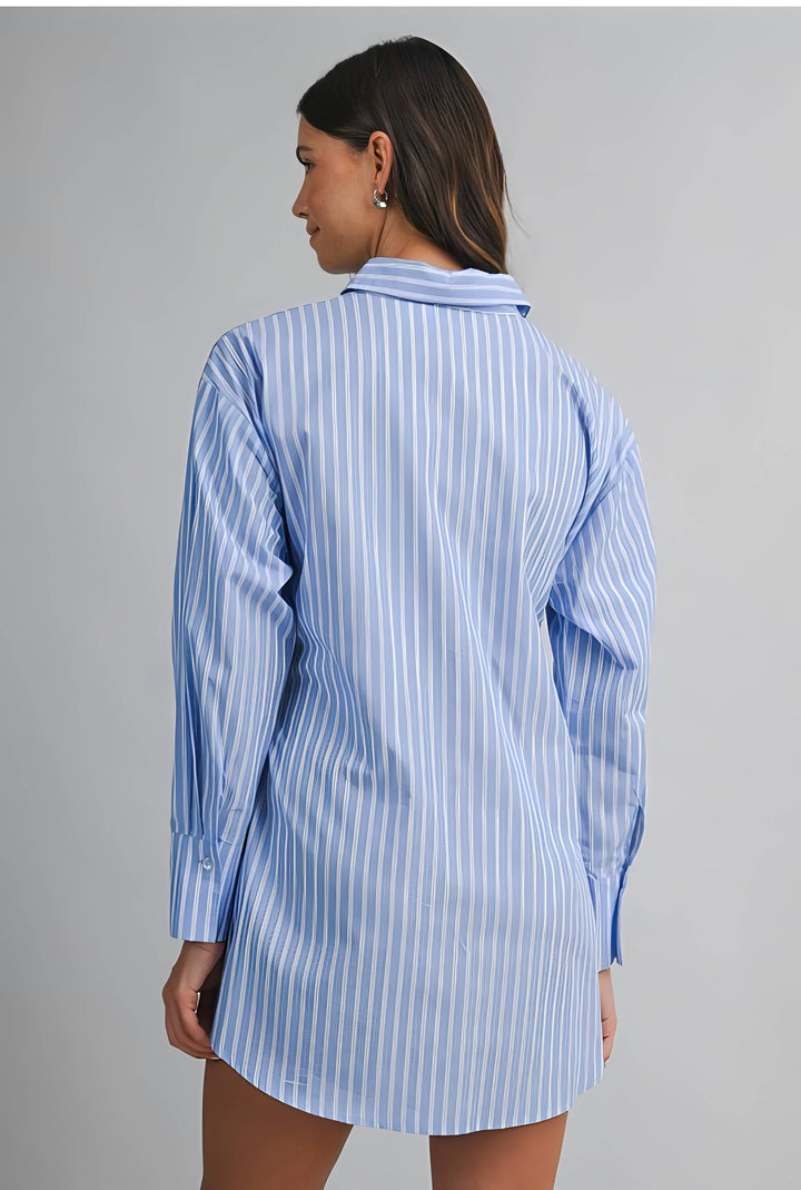 Woman wearing a blue and white striped shirt dress against a gray background