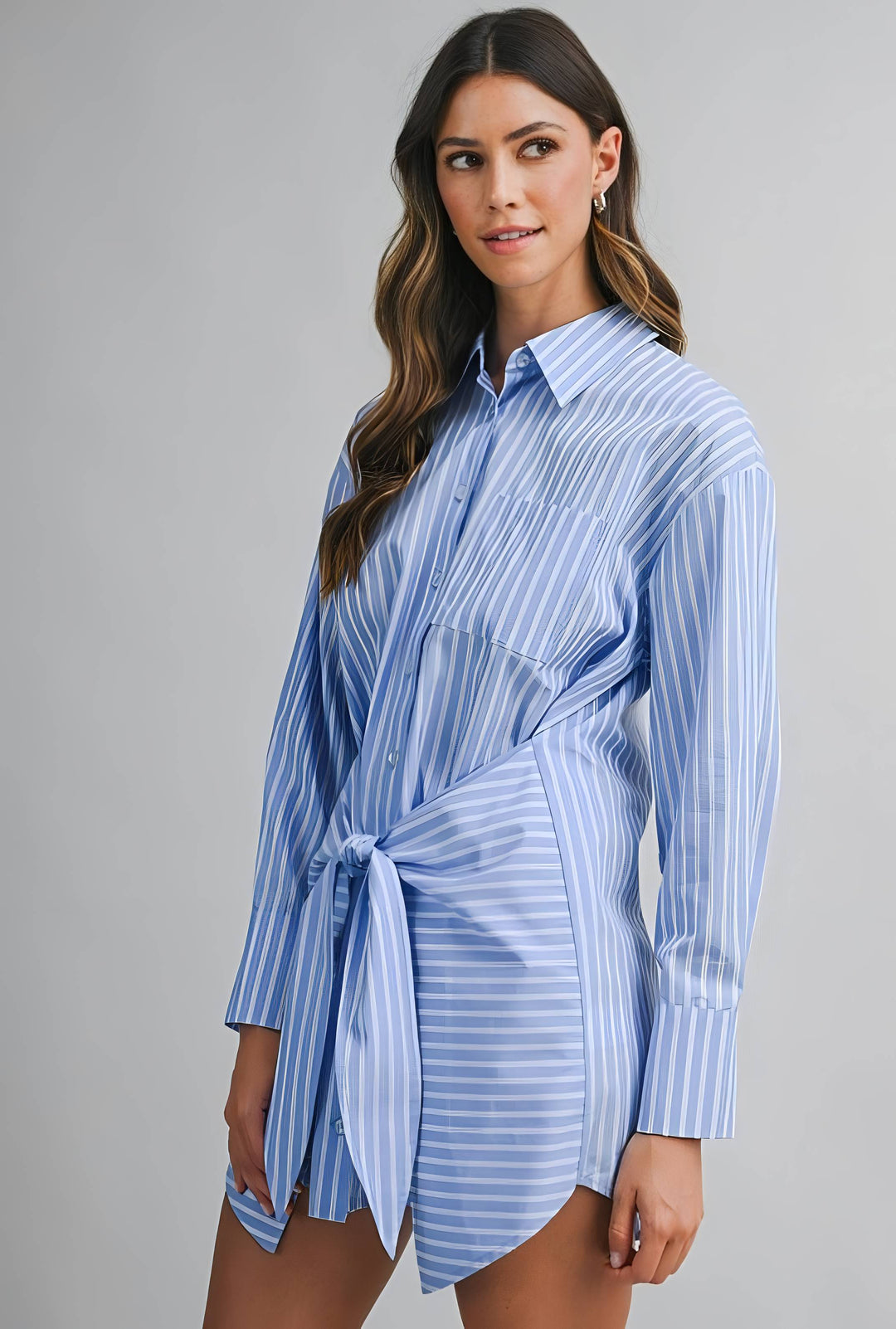 Woman wearing a blue and white striped dress against a gray background