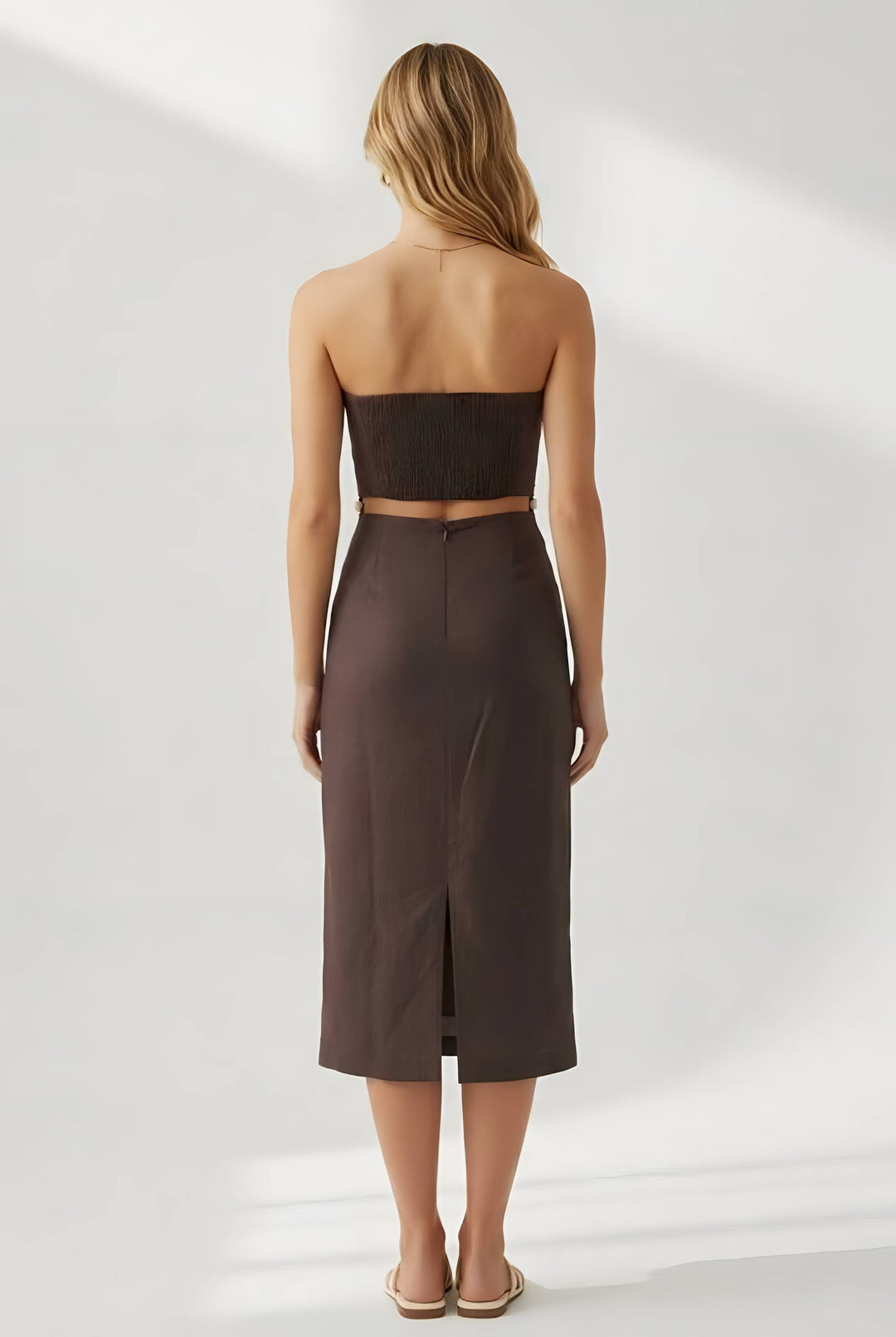 Woman wearing a strapless brown dress on a white background