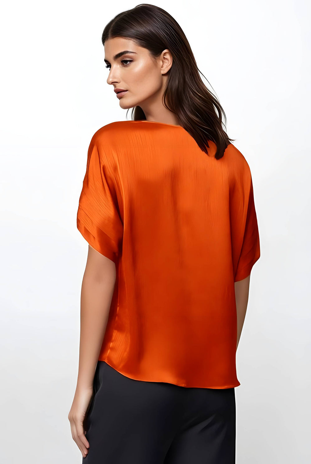 A woman wearing a bright orange short-sleeve satin blouse, shown from the back against a plain white studio background.