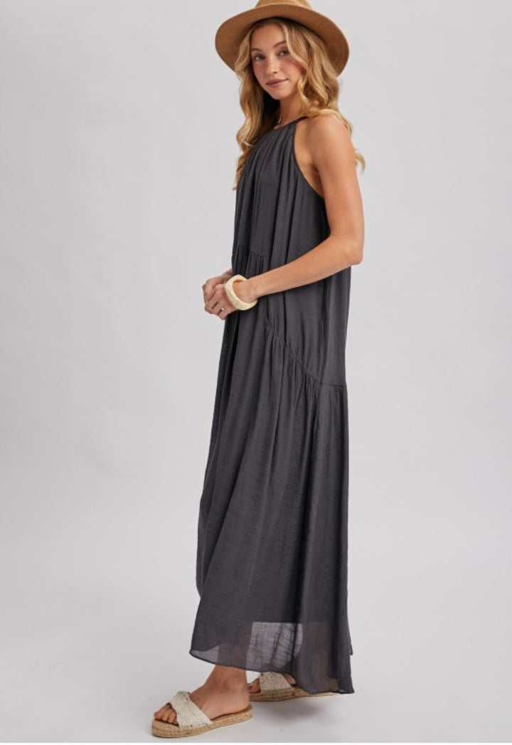 Woman wearing a sleeveless dark gray dress on a white background
