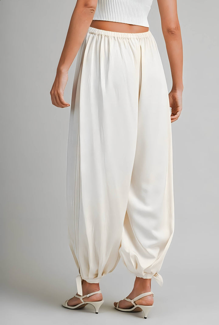Person wearing cream high-waisted pants on a plain background