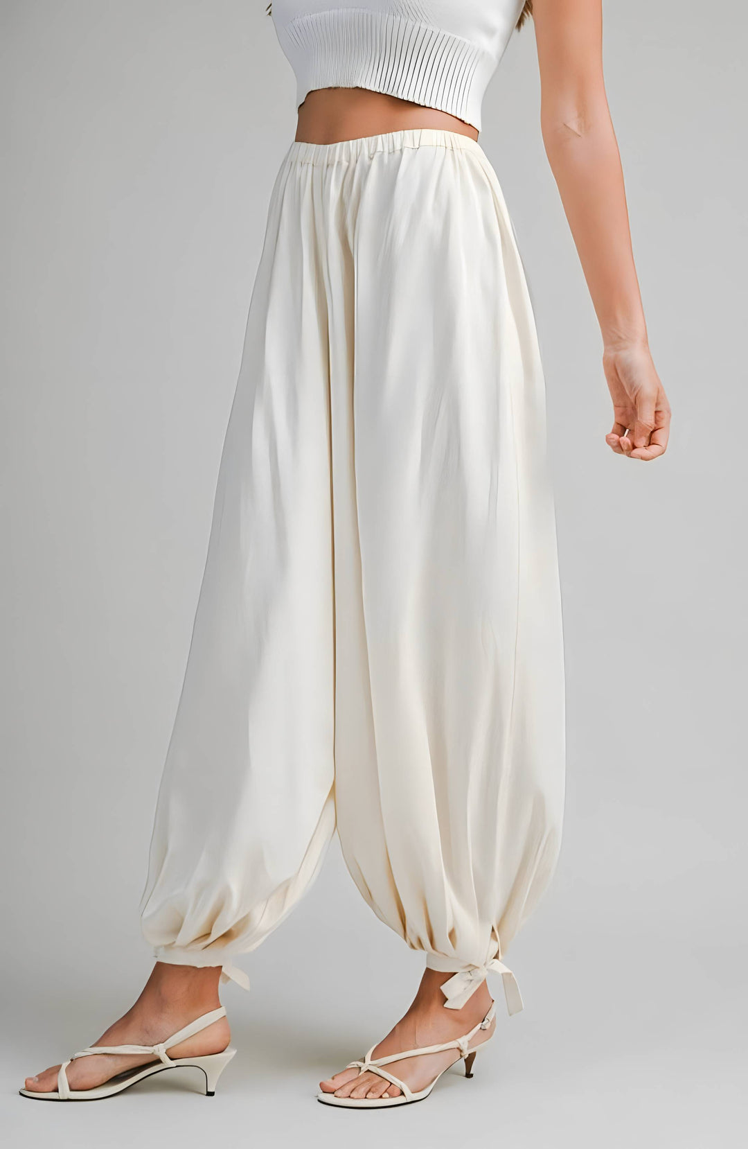 Cream wide-leg pants worn by a person on a gray background