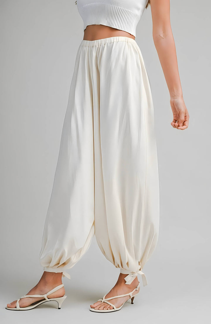 Cream wide-leg pants worn by a person on a gray background