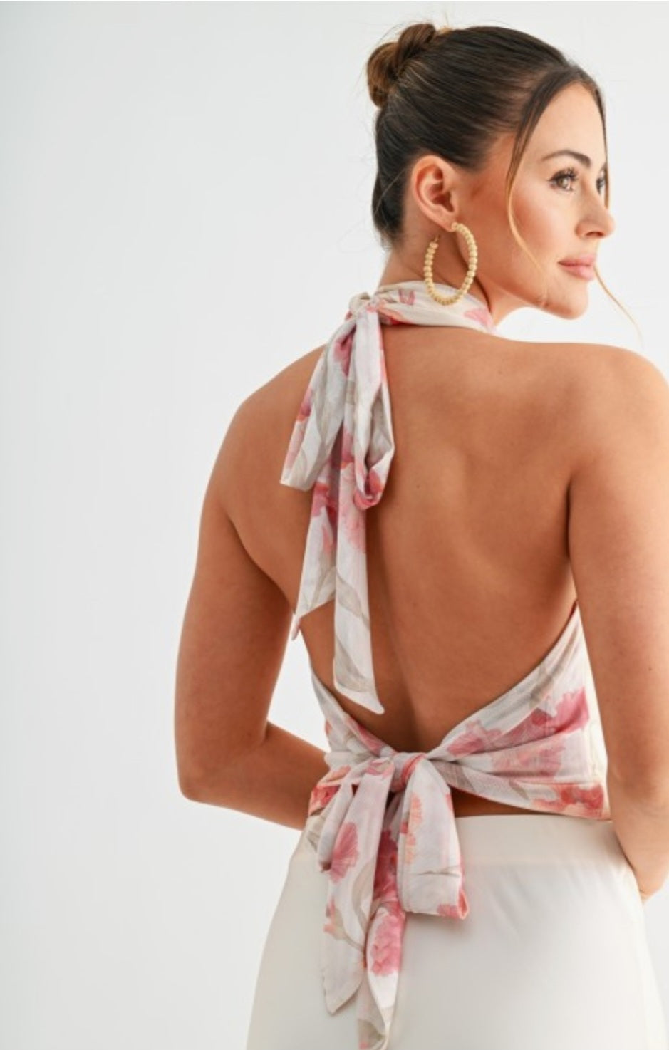 Woman wearing a floral halter top with a white background