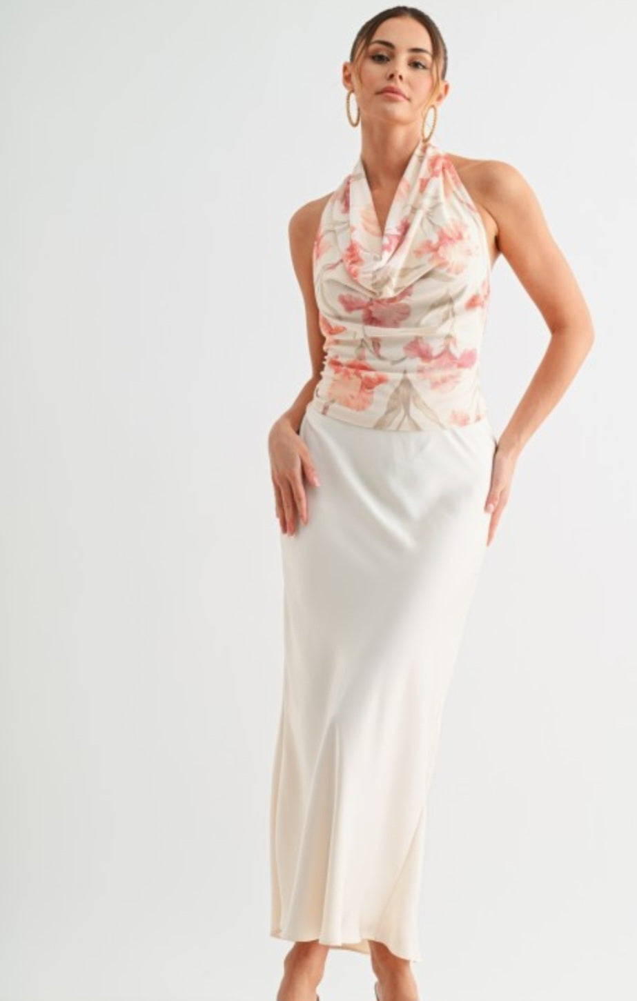 Woman wearing a floral halter neck dress with a plain background