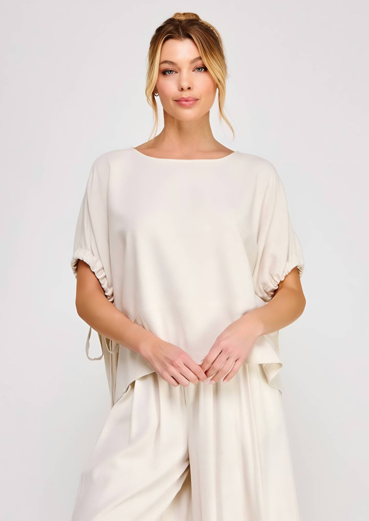 Woman wearing a beige top against a white background