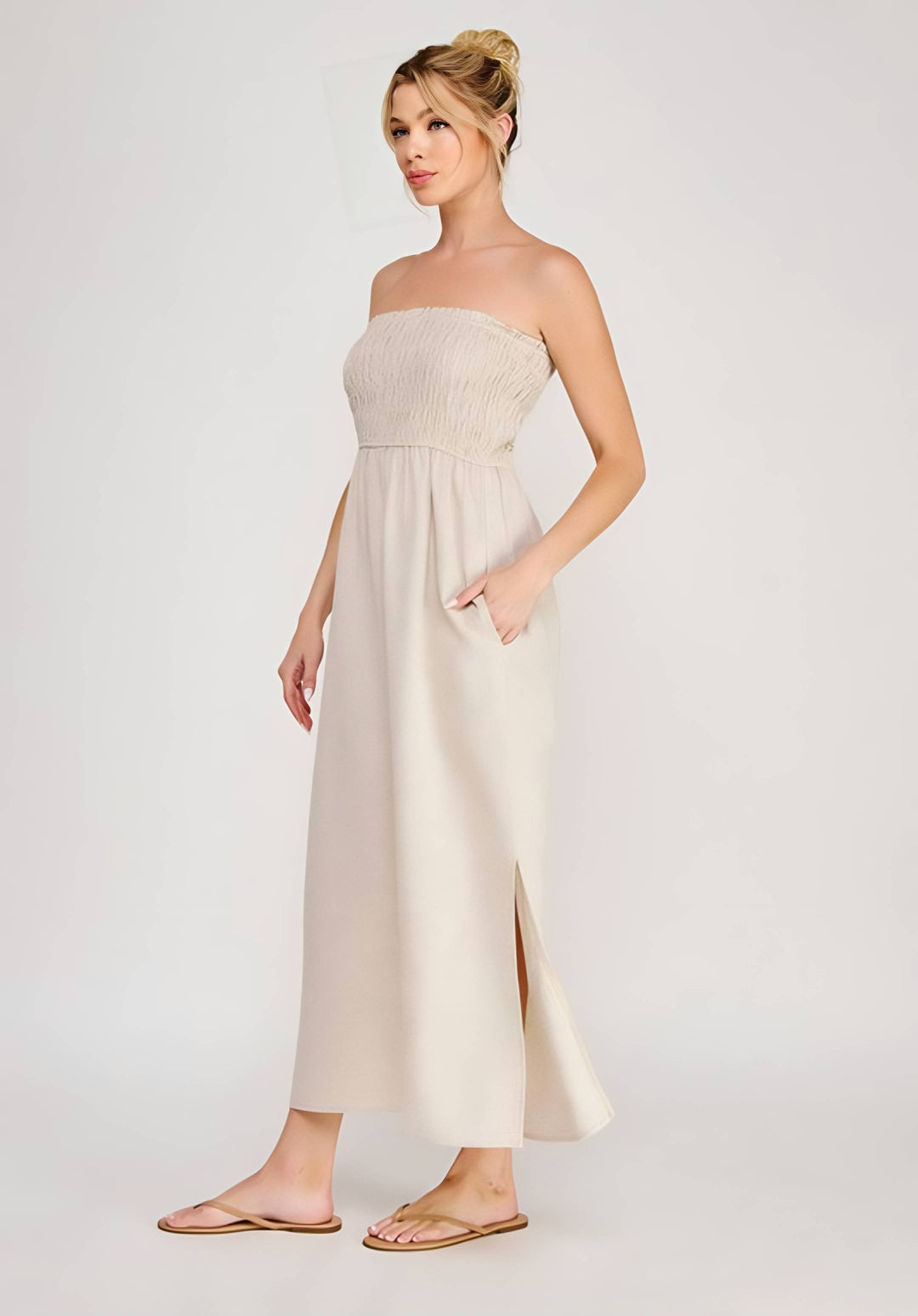 Woman wearing a strapless beige dress on a white background