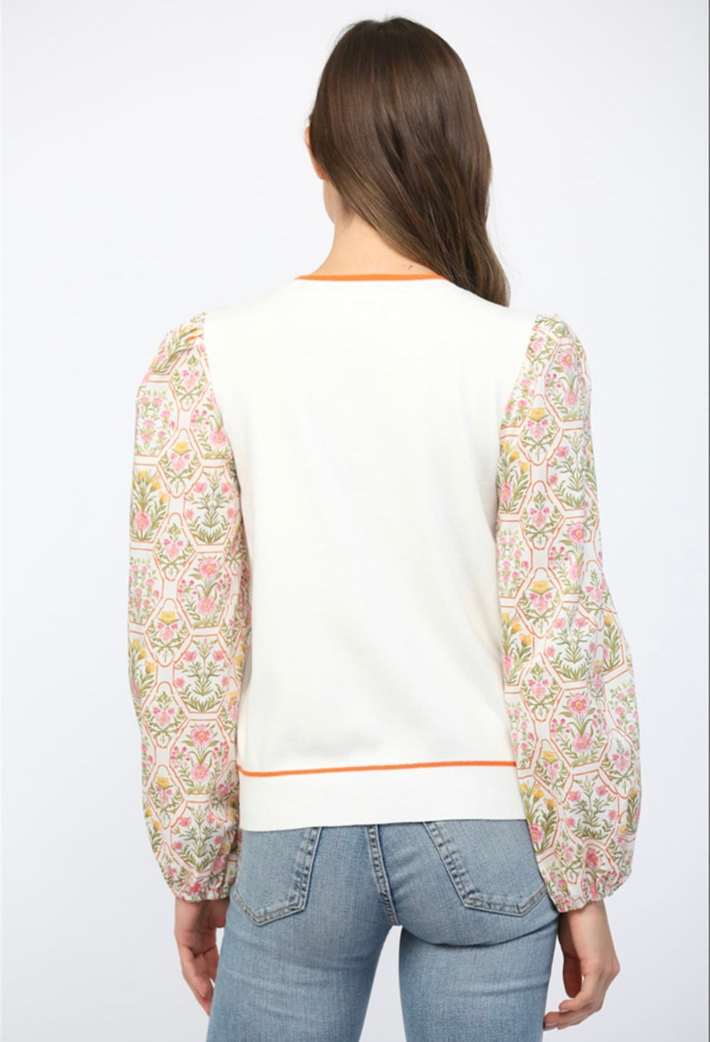 Women’s cream sweater with floral print sleeves and comfortable knit material