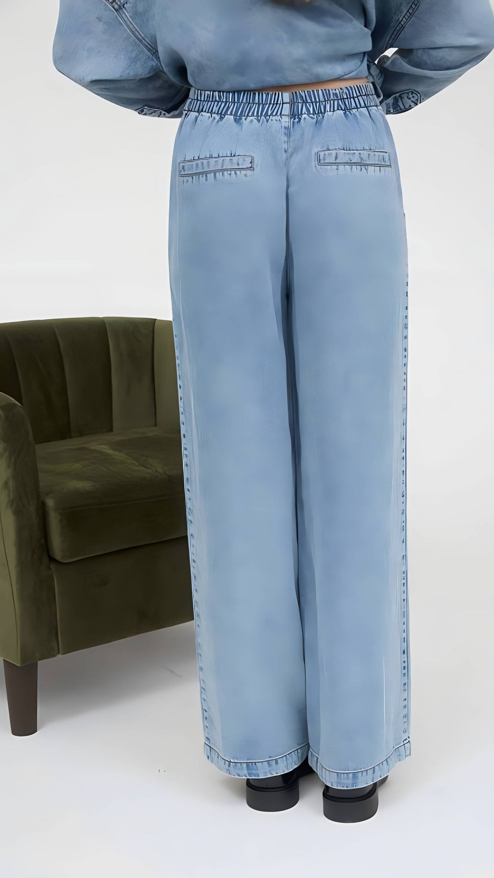 Light blue denim outfit with wide-leg pants and a cropped jacket on a white background.