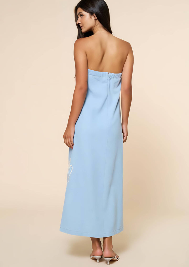 Woman wearing a light blue strapless dress against a beige background