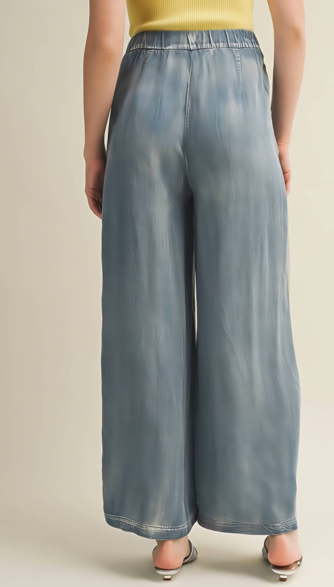Person wearing light blue wide-leg pants on a beige background
