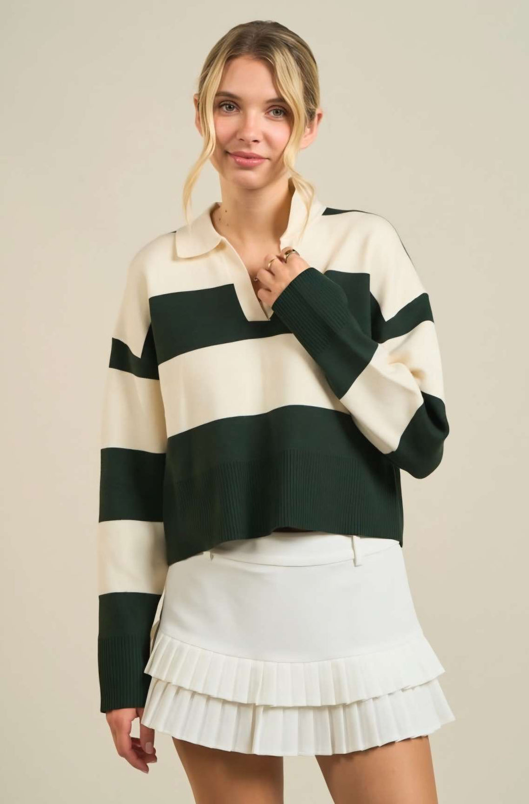 Women’s green stripe sweater polo with classic collar, long sleeves, and ribbed cuffs, styled for a chic smart-casual look.