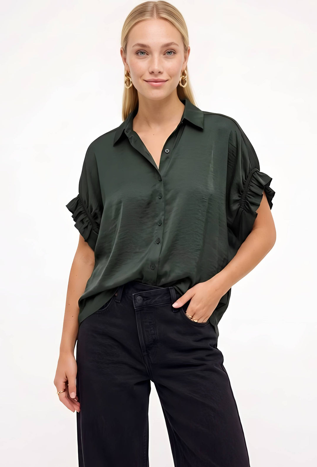 Model wearing a green button down ruffle sleeve top with dark jeans