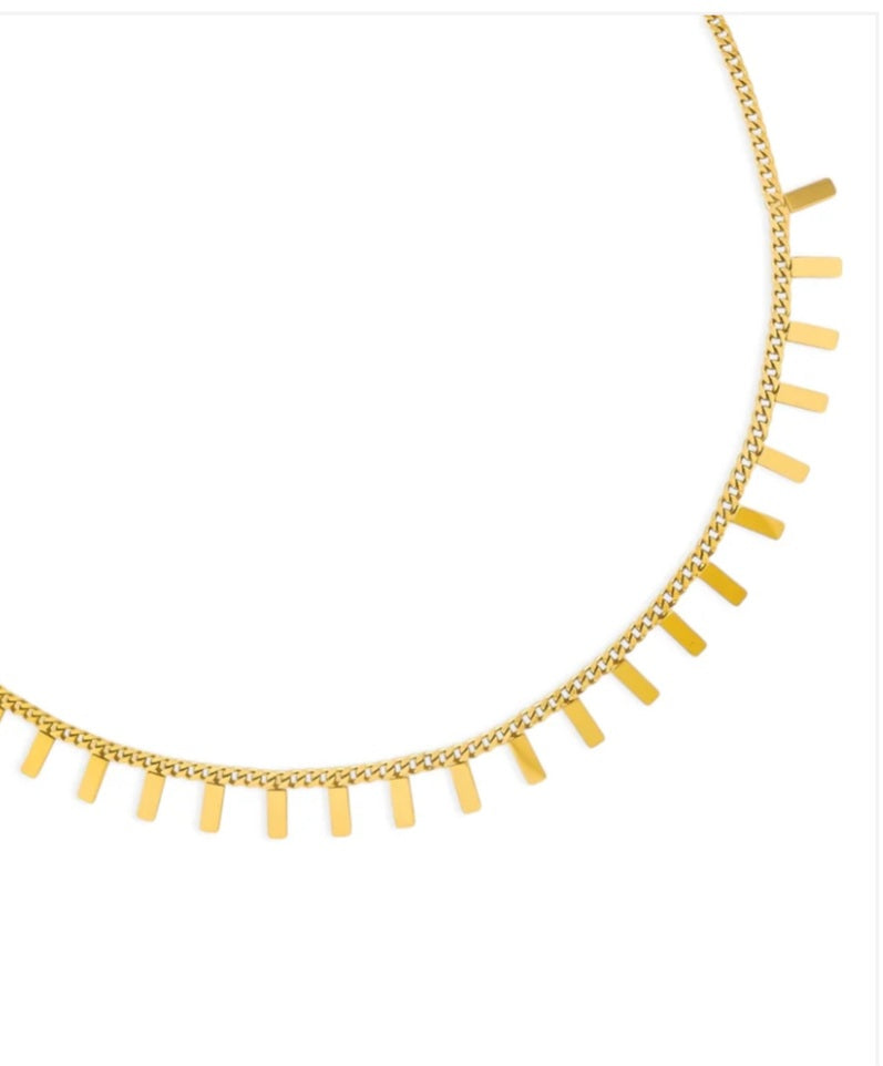 Gold necklace with fringe details on a white background