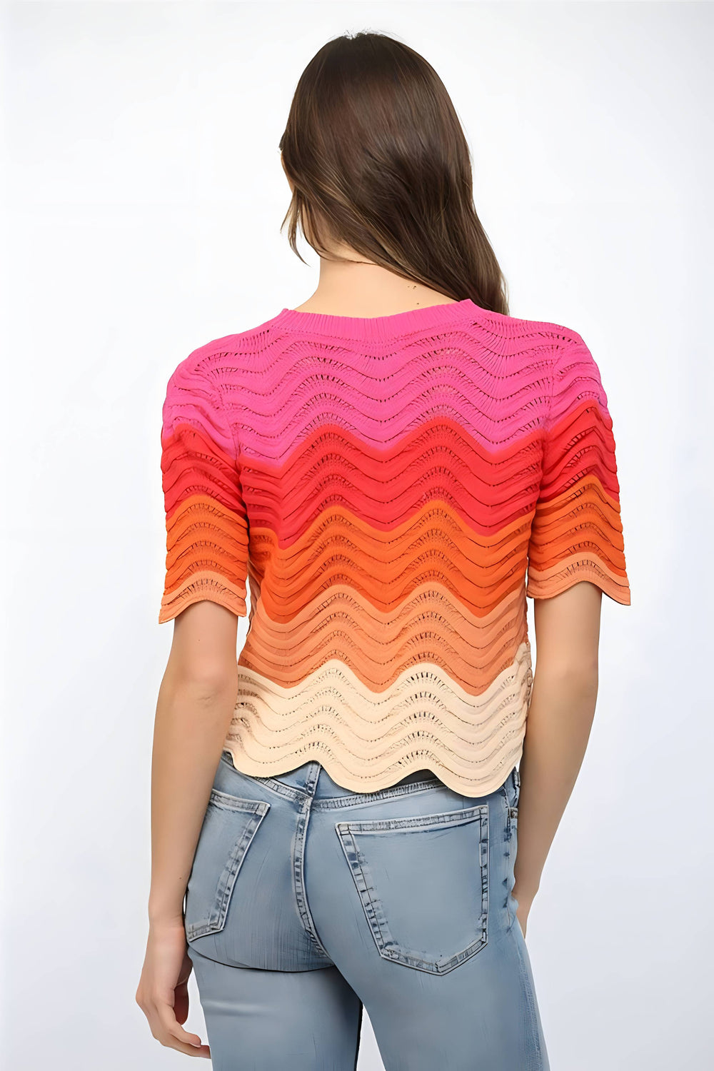 Woman wearing a colorful, patterned sweater with a white background