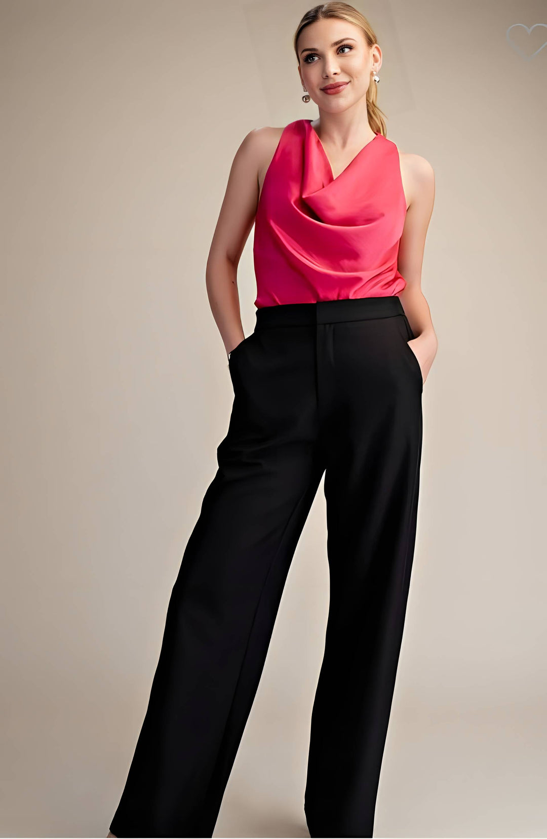 Woman wearing a bright pink sleeveless top and black pants against a beige background
