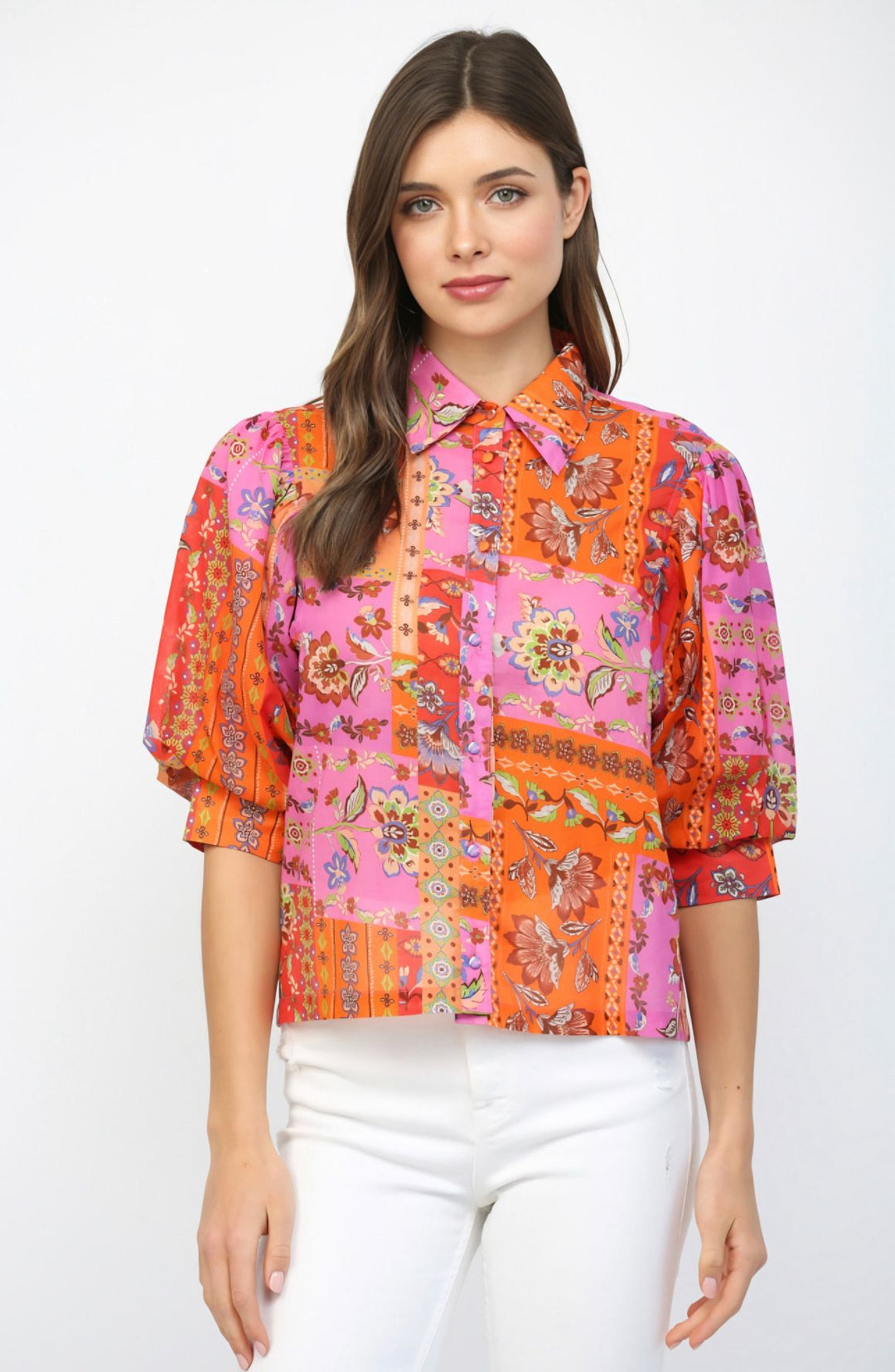 Woman wearing a colorful patterned blouse on a white background