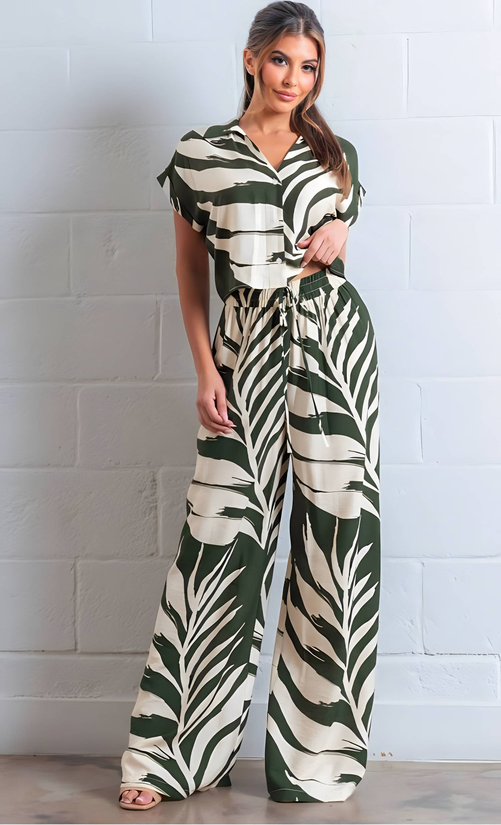 Woman wearing a zebra print jumpsuit against a white brick wall.