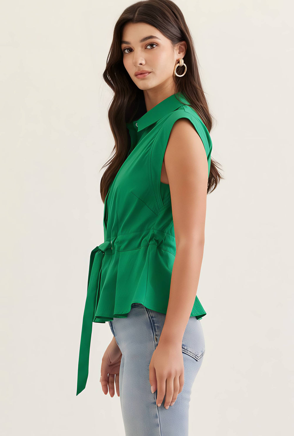 Woman wearing a green sleeveless top with a plain background