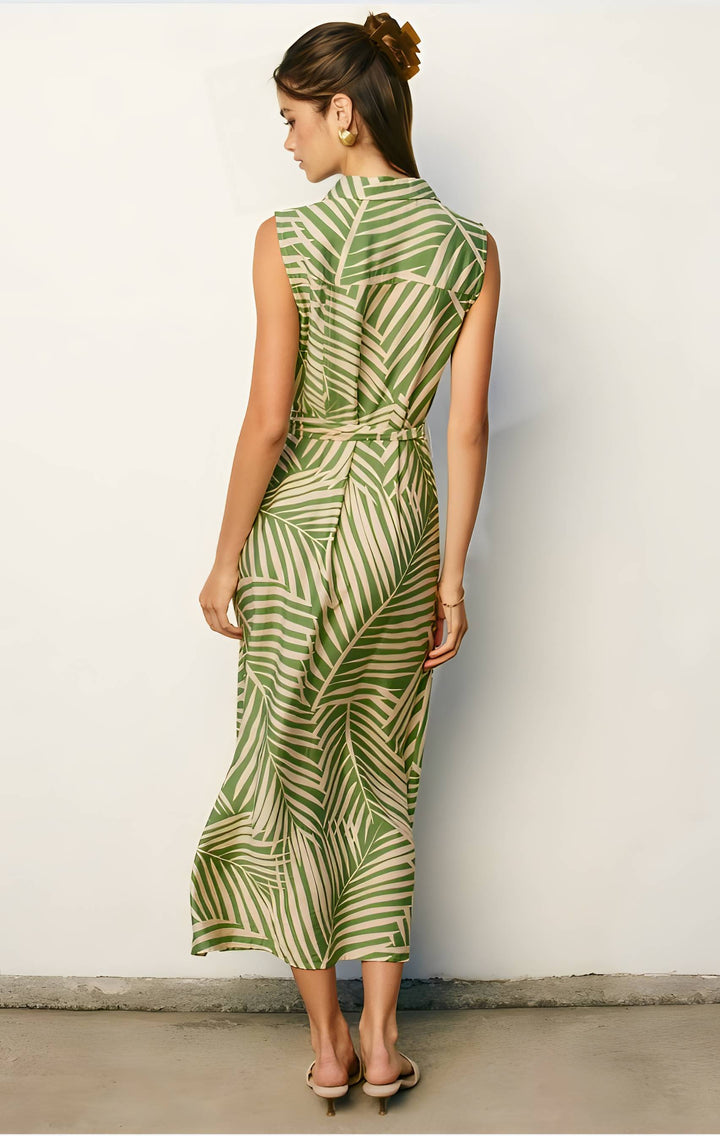 Woman wearing a green and white patterned dress against a plain background