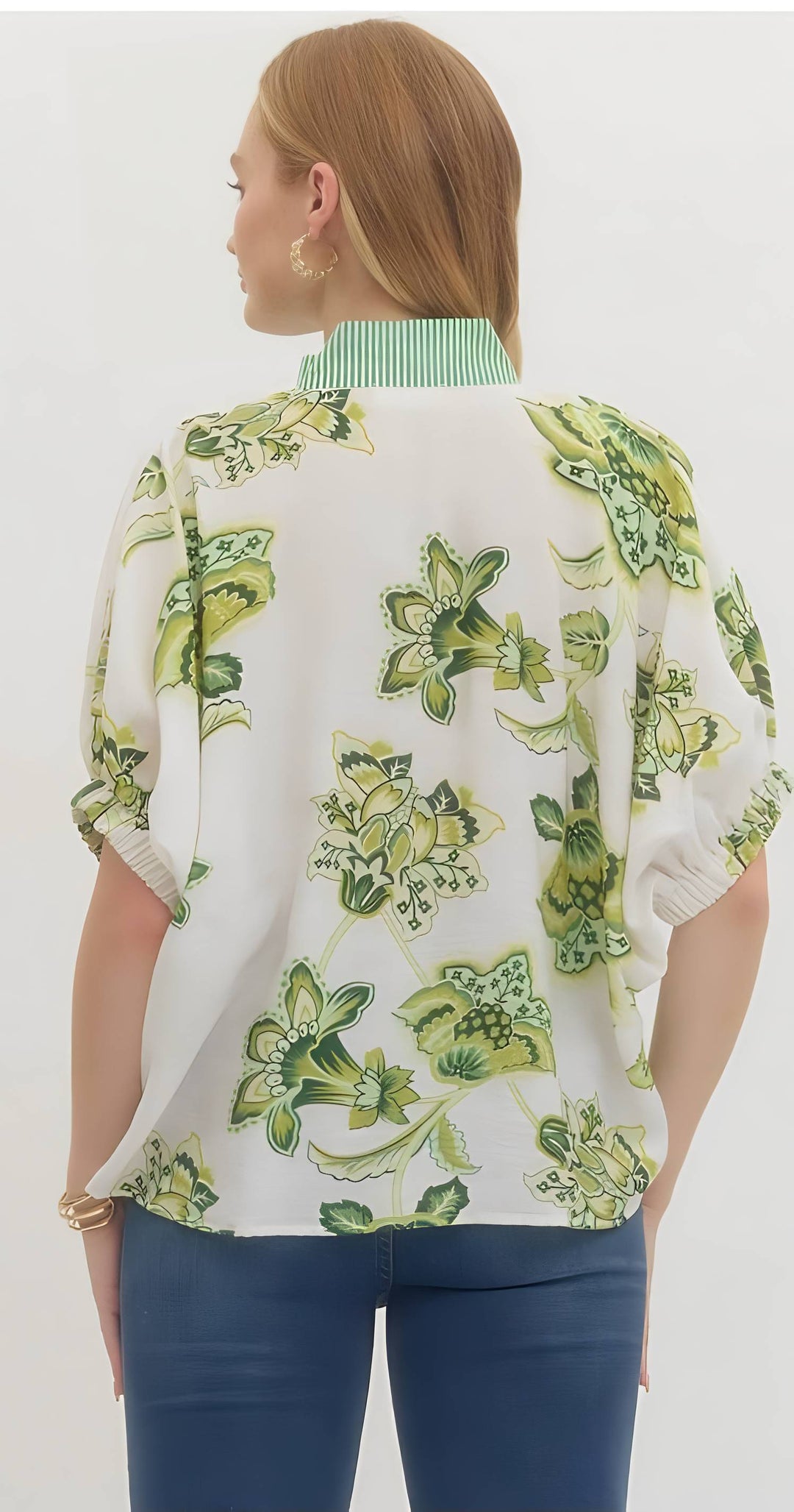 Woman wearing a floral patterned blouse with a white background