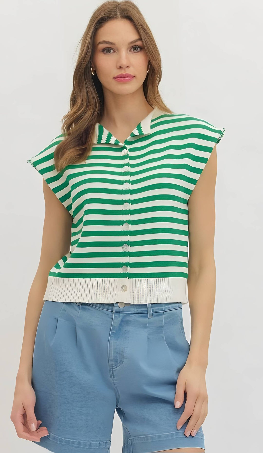 Woman wearing a green and white striped shirt with blue shorts on a white background