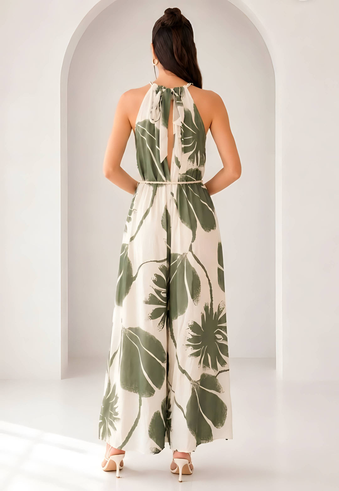 Woman wearing a leaf-patterned jumpsuit standing in front of an archway.