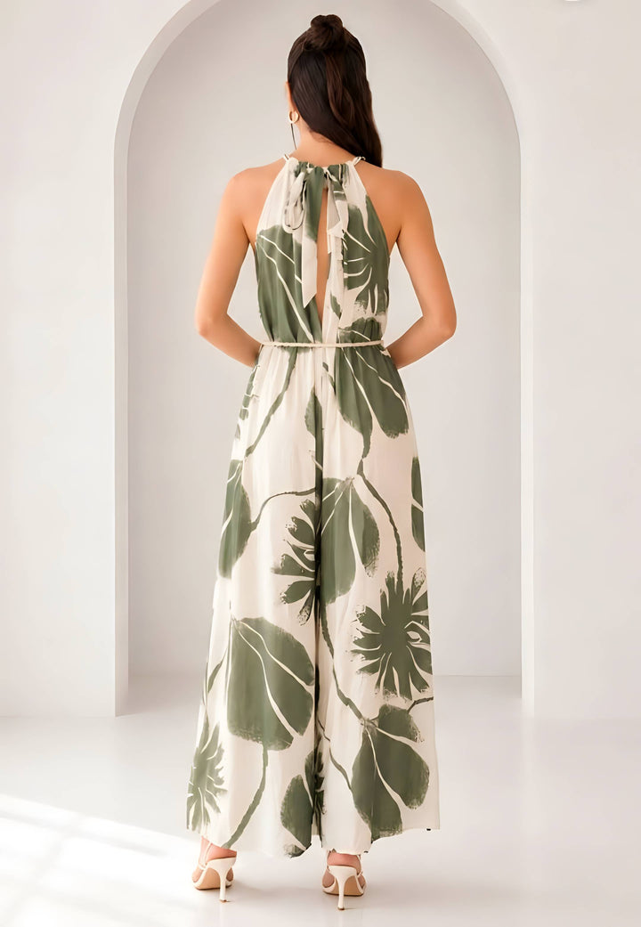 Woman wearing a leaf-patterned jumpsuit standing in front of an archway.