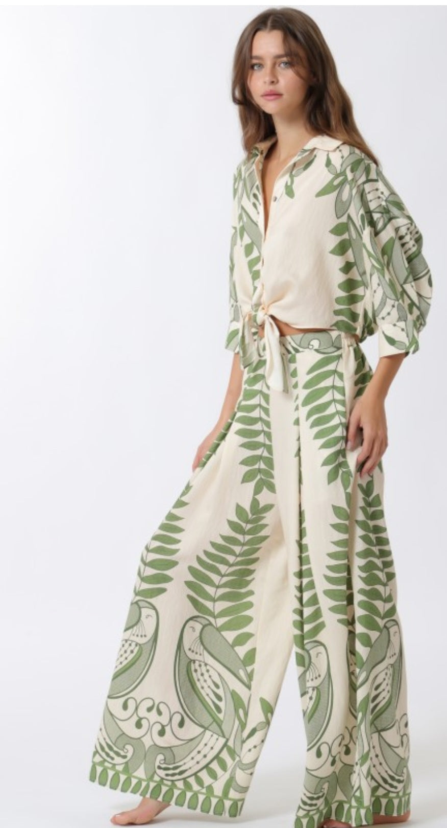 Woman wearing a green and white patterned outfit on a white background