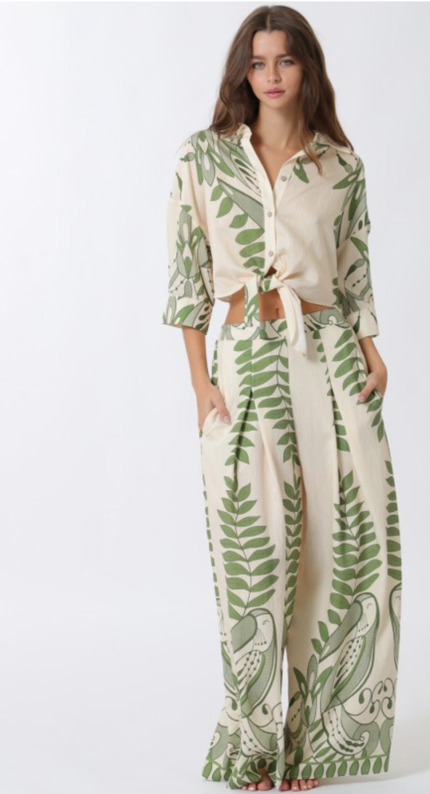 Woman wearing a leaf-patterned jumpsuit on a white background