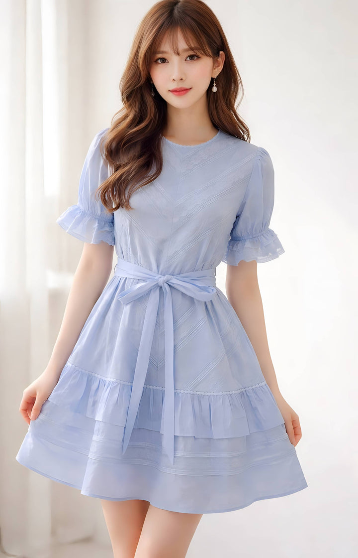 Woman wearing a light blue dress with a white background