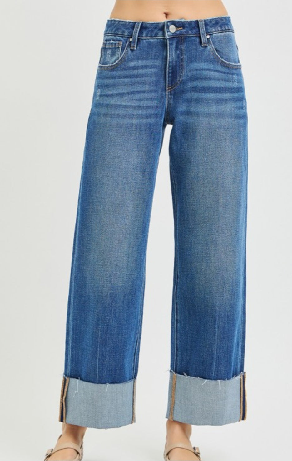 Blue jeans with rolled-up cuffs on a white background