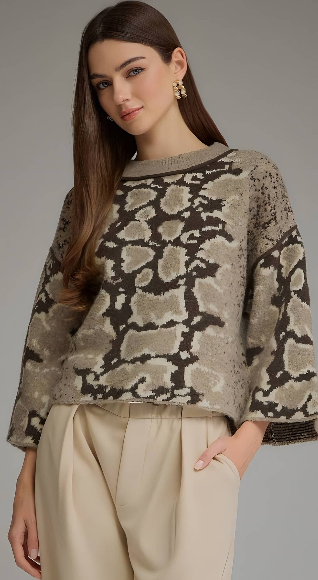 Model wearing a mocha print round neck sweater with beige pants.