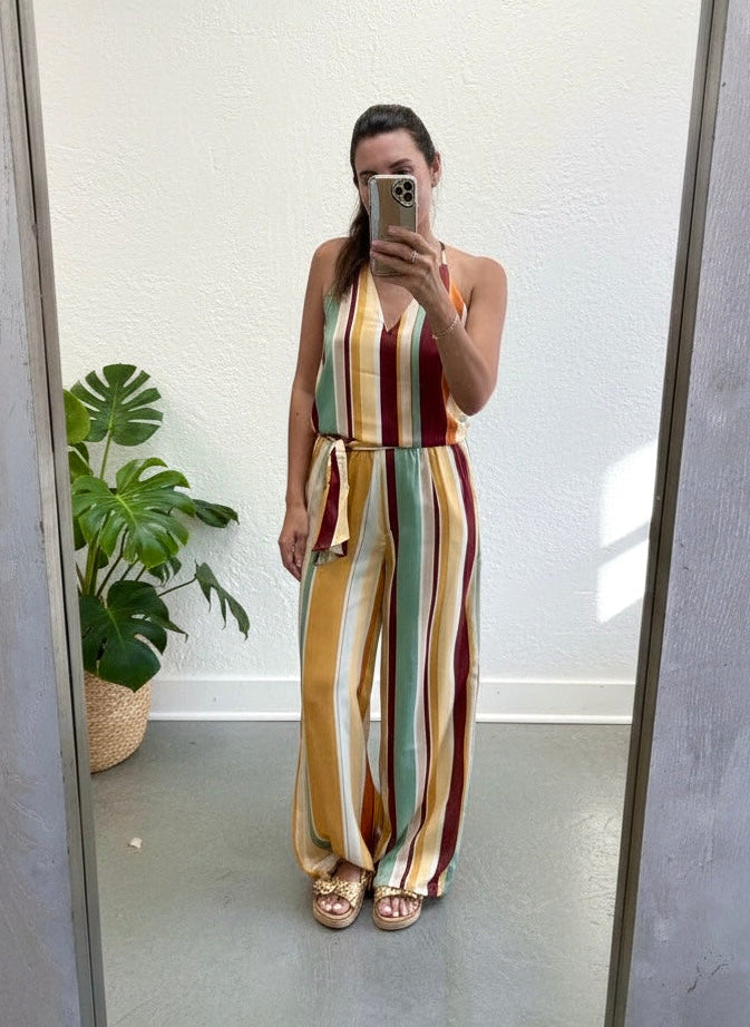 Person wearing a colorful striped jumpsuit taking a mirror selfie.