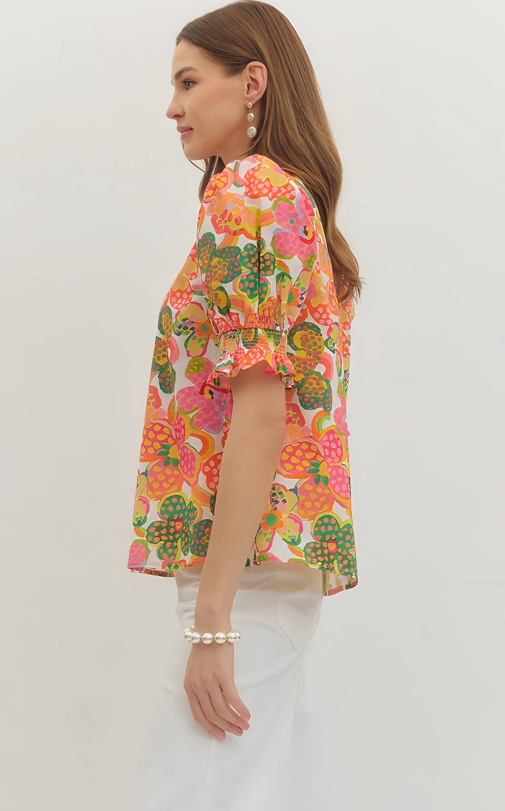 Woman wearing a colorful floral blouse on a white background