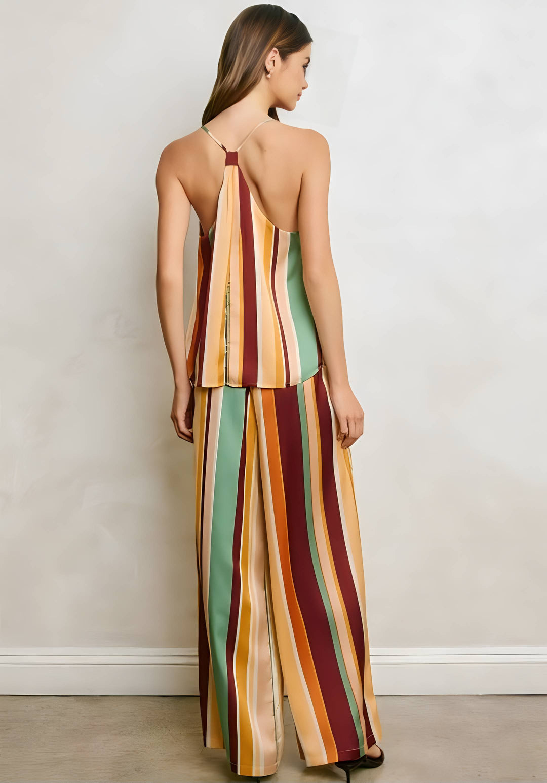 Woman wearing a colorful striped pant set against a plain background