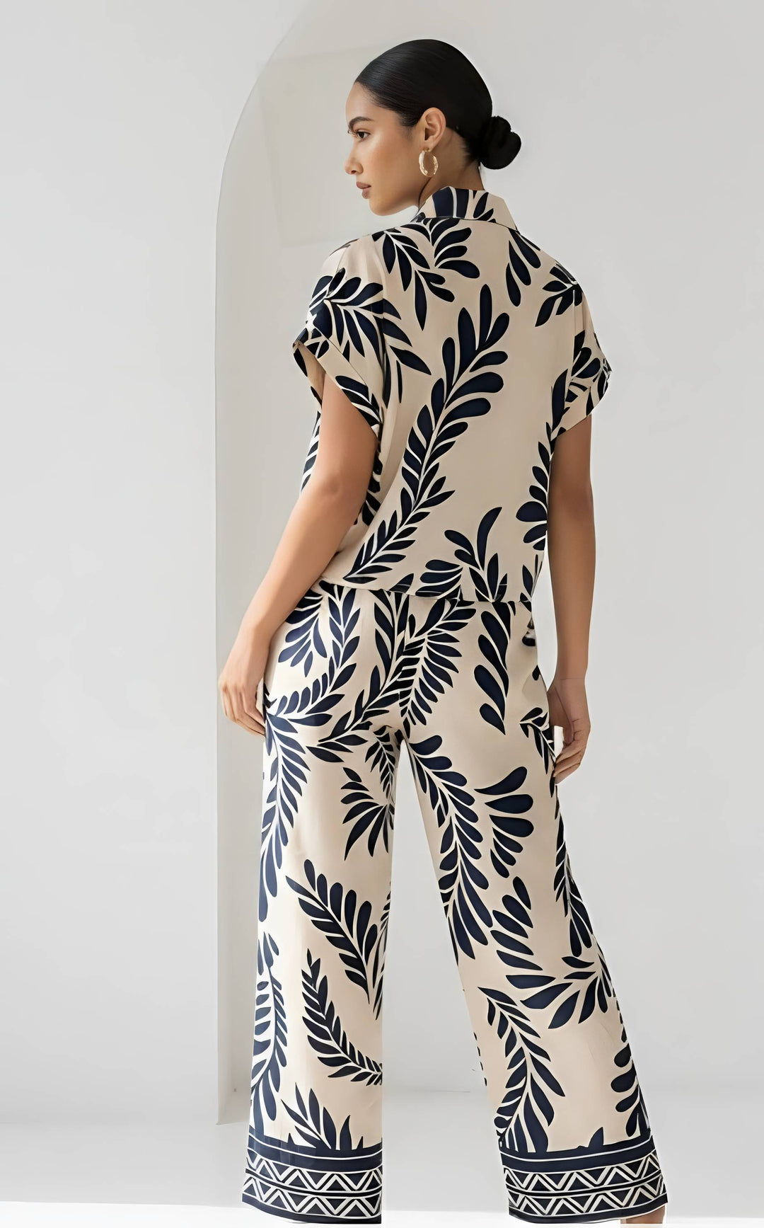 Woman wearing a leaf-patterned outfit against a white background