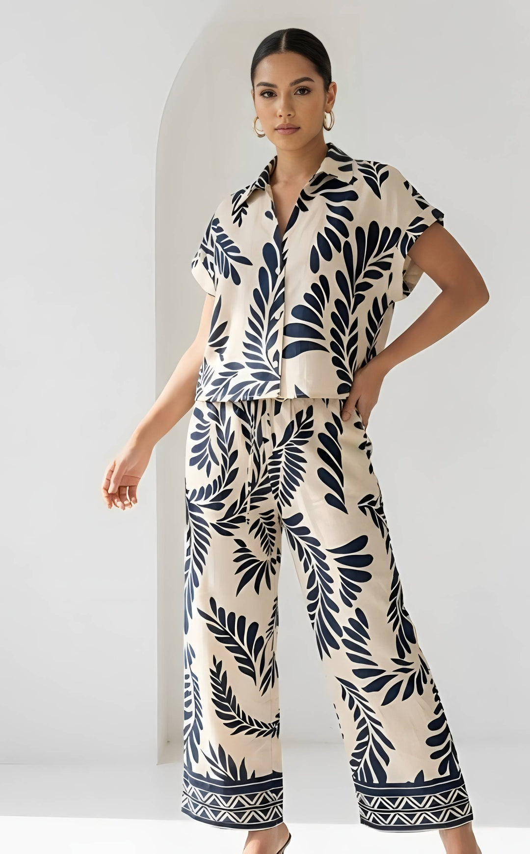 Woman wearing a navy leaf pattern outfit against a white background