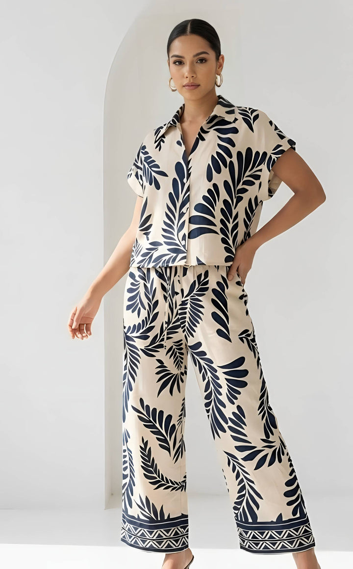 Woman wearing a navy leaf pattern outfit against a white background